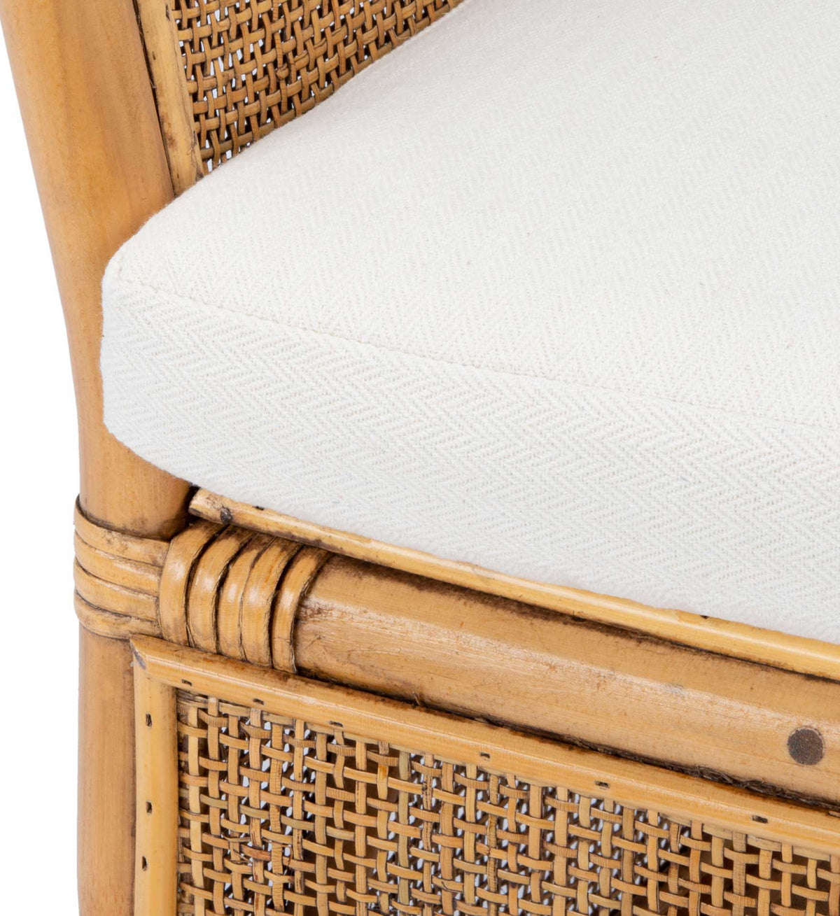 A white cushion with subtle woven texture rests above bound honey-brown rattan joints