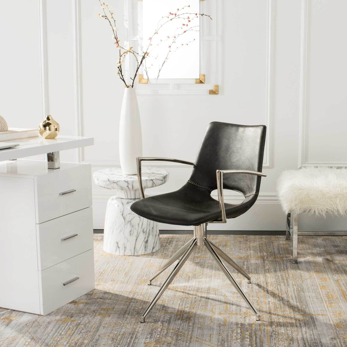 A dark gray faux leather swivel chair with slim silver arms brings midcentury style to a bright home office