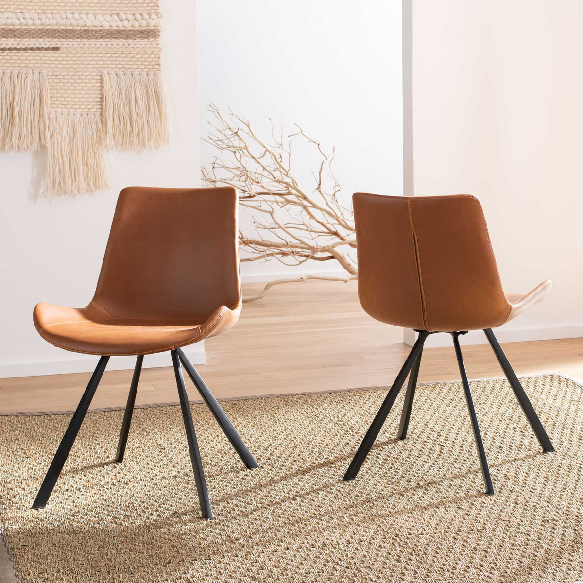 A pair of cognac faux leather chairs adds warm color and sculptural lines to a living space