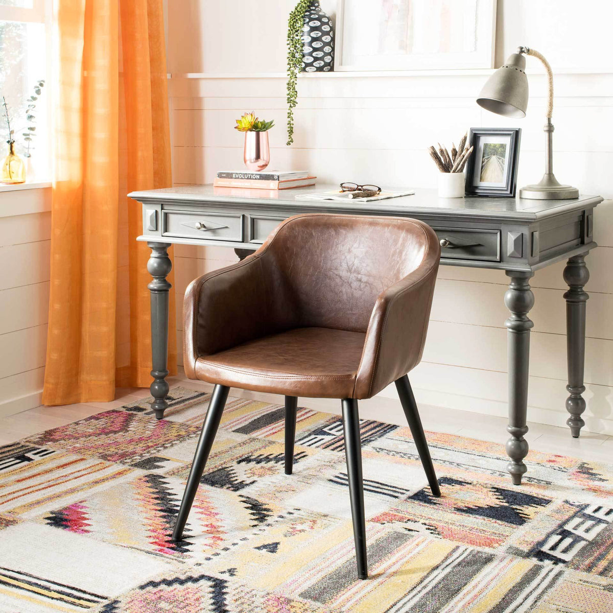 Curved brown faux leather arms and a padded seat bring inviting comfort to a workspace.