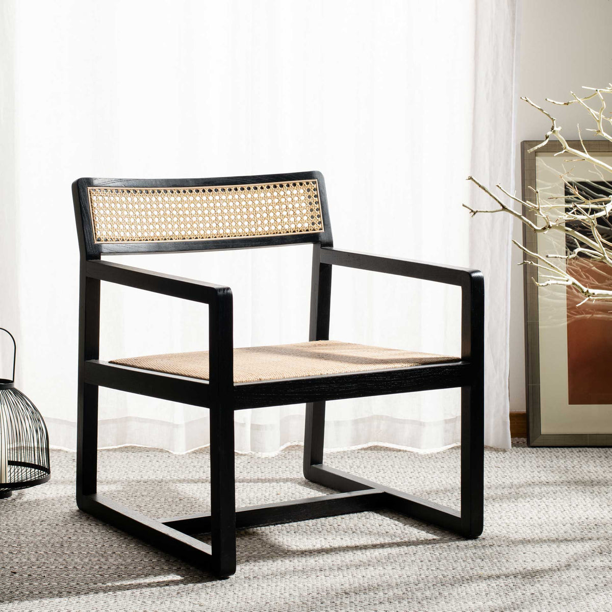 Black wood arms and warm cane details bring graphic contrast to a light, airy interior.