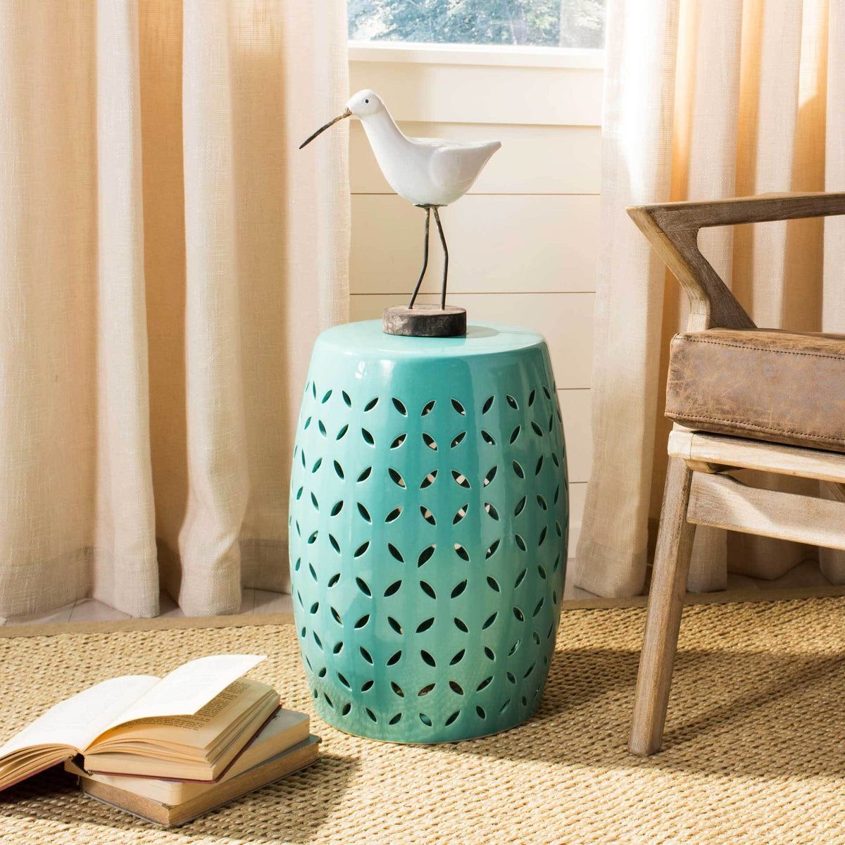 Blue ceramic stool brightens a sunlit room beneath a decorative bird