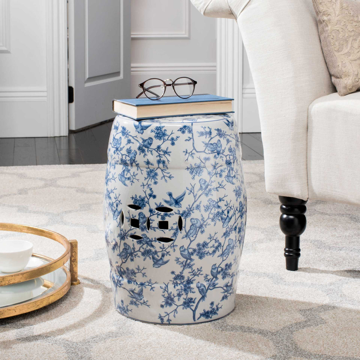 Blue-and-white garden stool doubles as a side table beside a living room chair