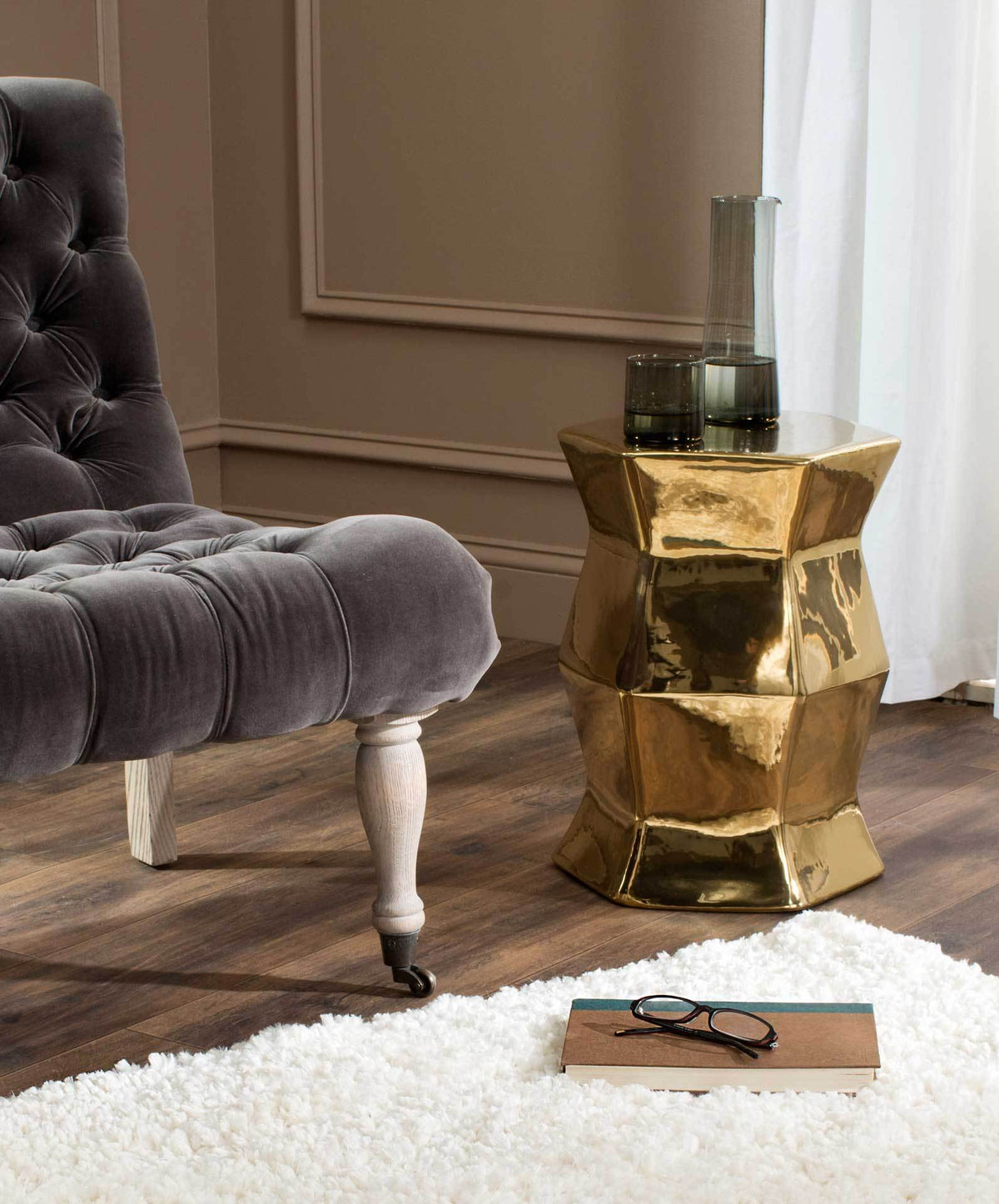 A gold ceramic stool adds a lustrous accent and a handy tabletop beside plush seating.