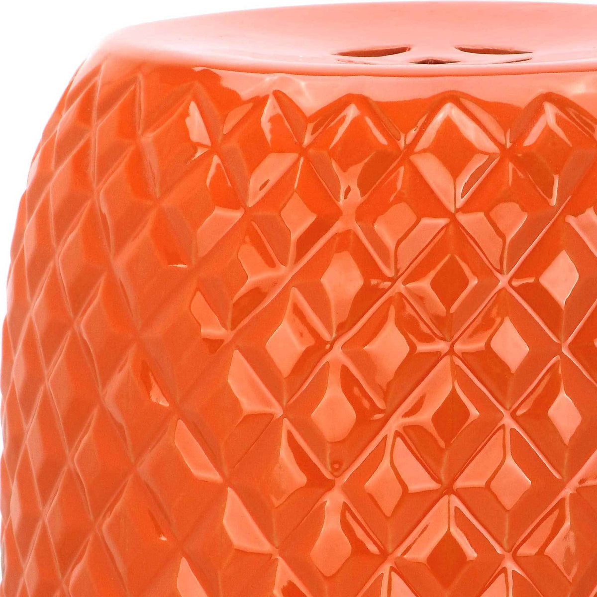 Raised geometric facets catch the light beneath a glossy orange glaze