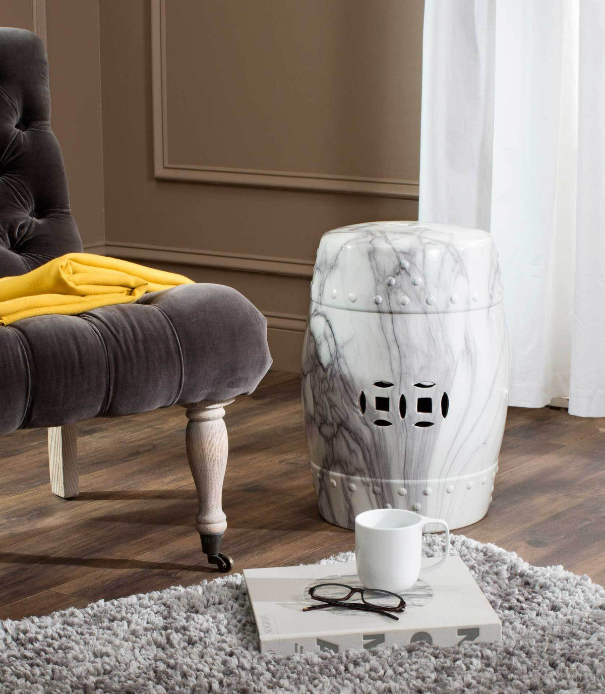 Gray-veined ceramic garden stool with pierced motifs adds sculptural charm to a seating area