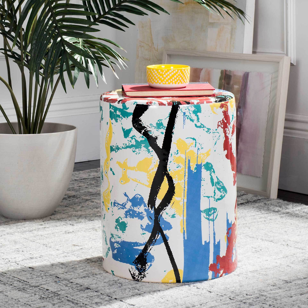Colorful ceramic garden stool with bold abstract brushstrokes and a flat top that doubles as a side table