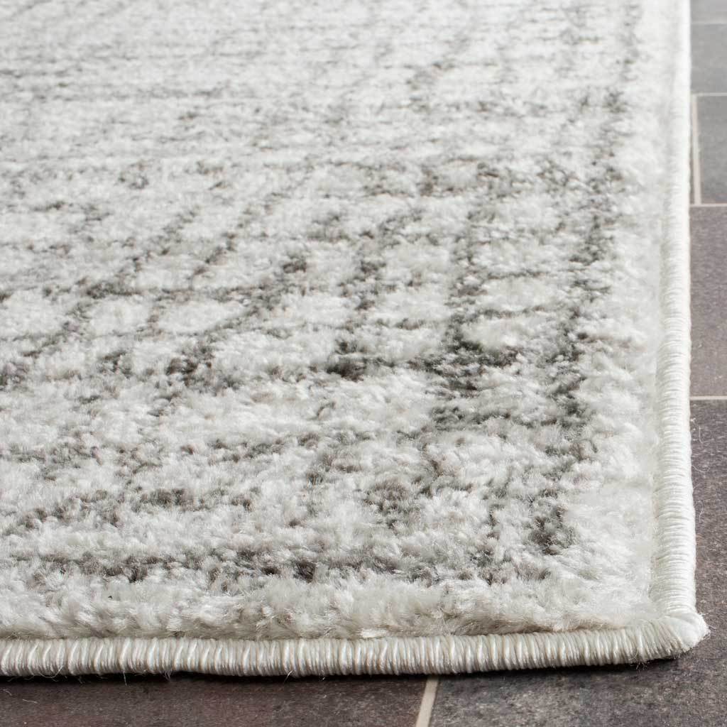 Soft, textured pile brings dimension to the silver and ivory pattern, finished with a neatly bound edge.