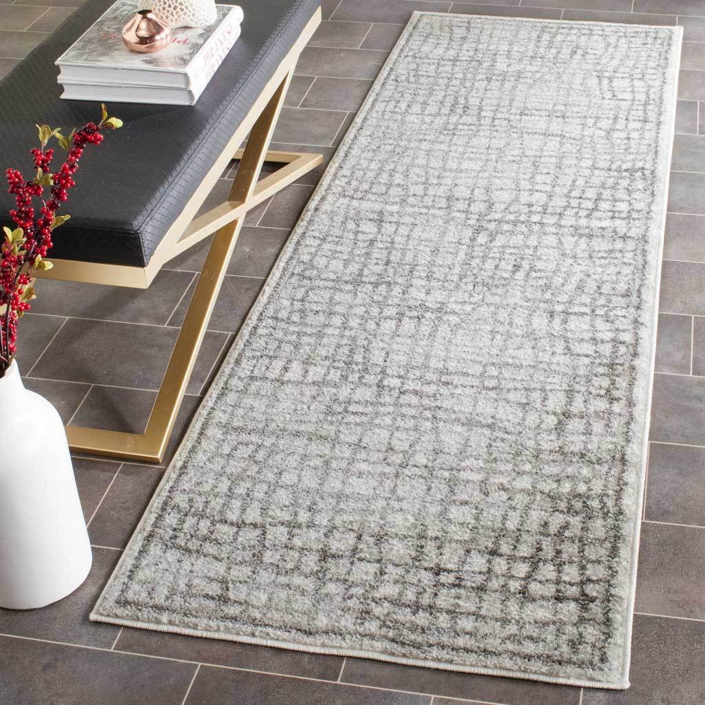 A silver and ivory runner adds softly distressed pattern and understated texture to a modern tiled space.