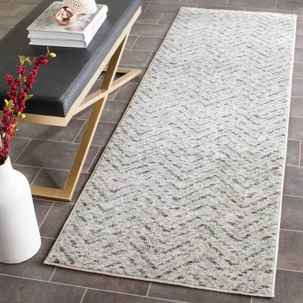Softly distressed charcoal chevrons give this ivory runner subtle contrast on dark tile