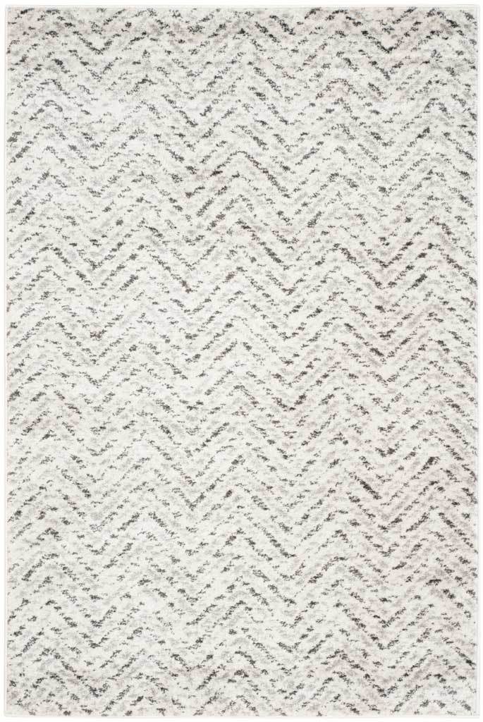 Dappled charcoal zigzags give this ivory rectangular rug understated texture