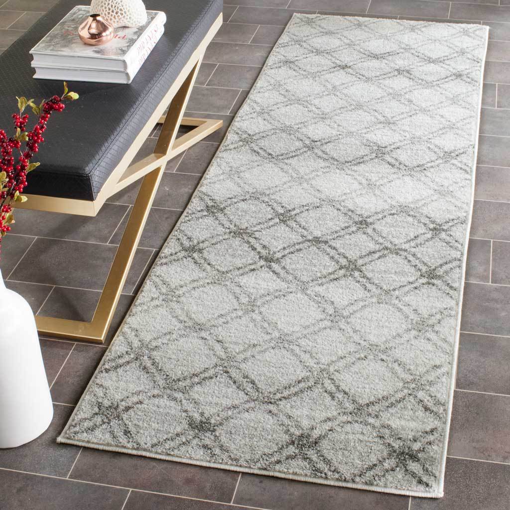 Silver and charcoal trellis runner adds soft geometric style beside a black and gold console