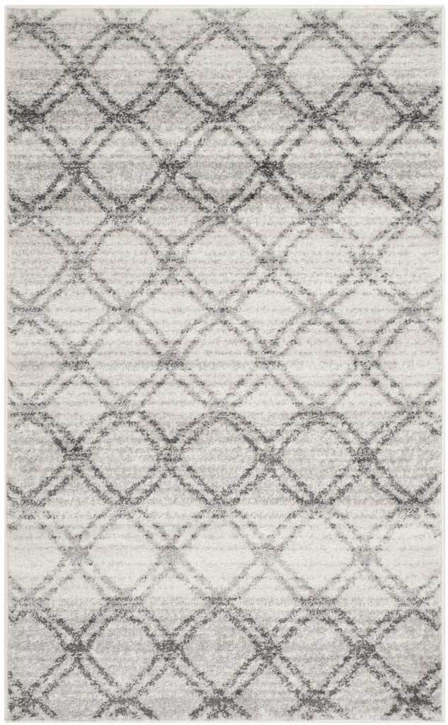 Intersecting charcoal diamonds lend pattern to this compact silver rug