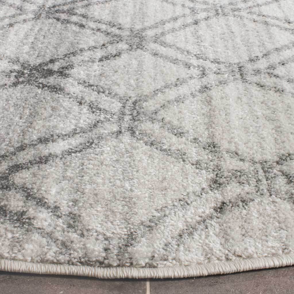 Soft silver pile and a neatly bound edge accent the charcoal geometric pattern
