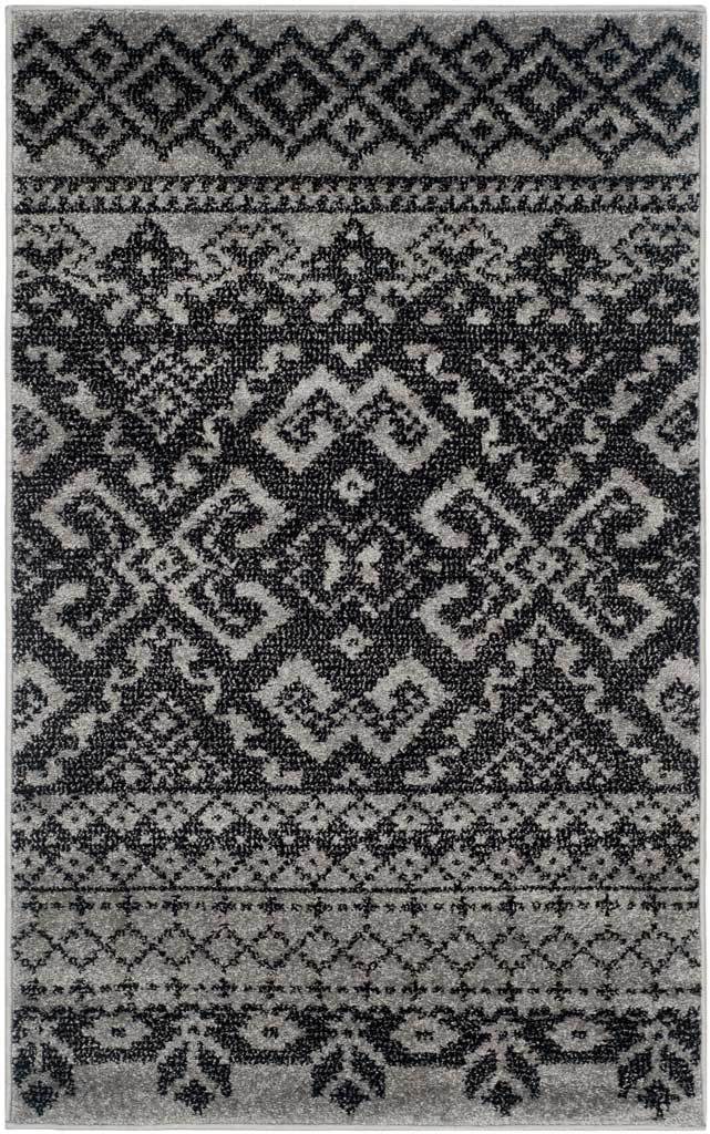 Compact silver and black rug centers a dramatic diamond medallion between decorative borders.