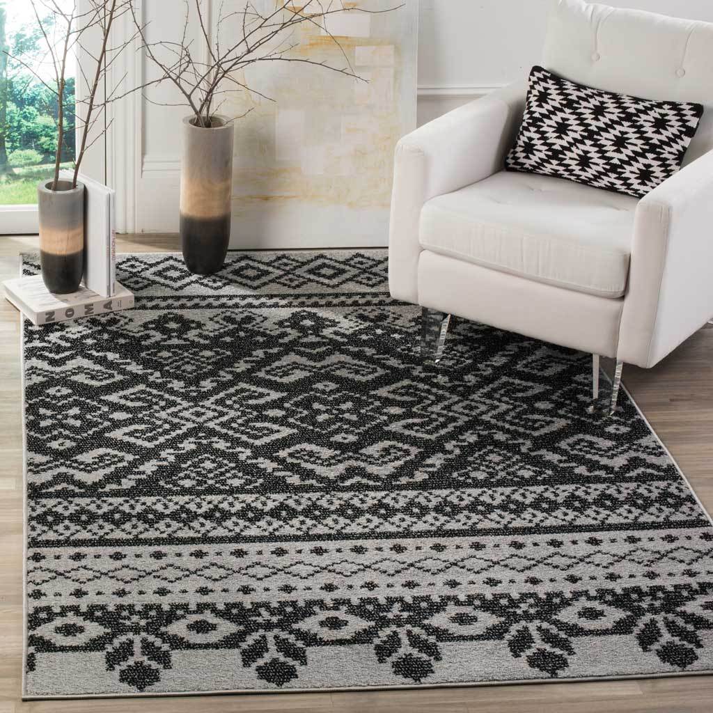 Graphic black diamonds and decorative borders give a silver area rug striking contrast.