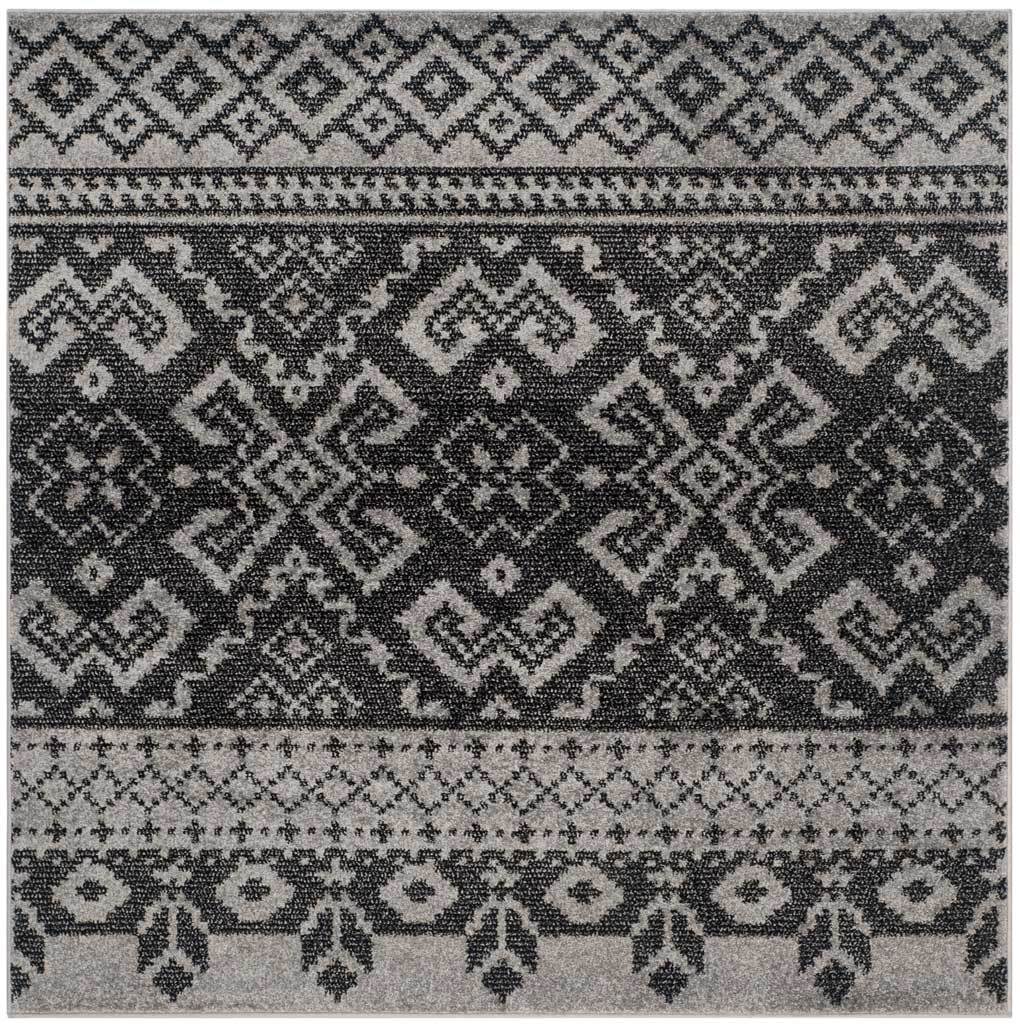 Square silver and black rug features repeating diamond medallions and intricate patterned borders.