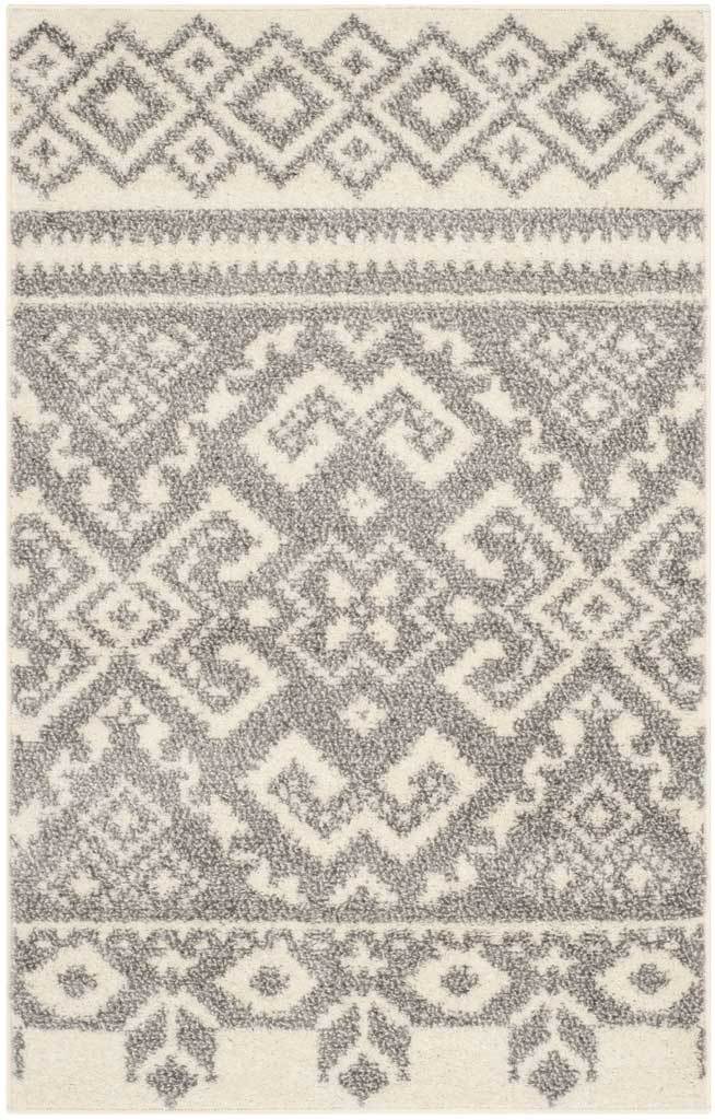 Small ivory and silver accent rug features a striking central medallion and delicate patterned borders.