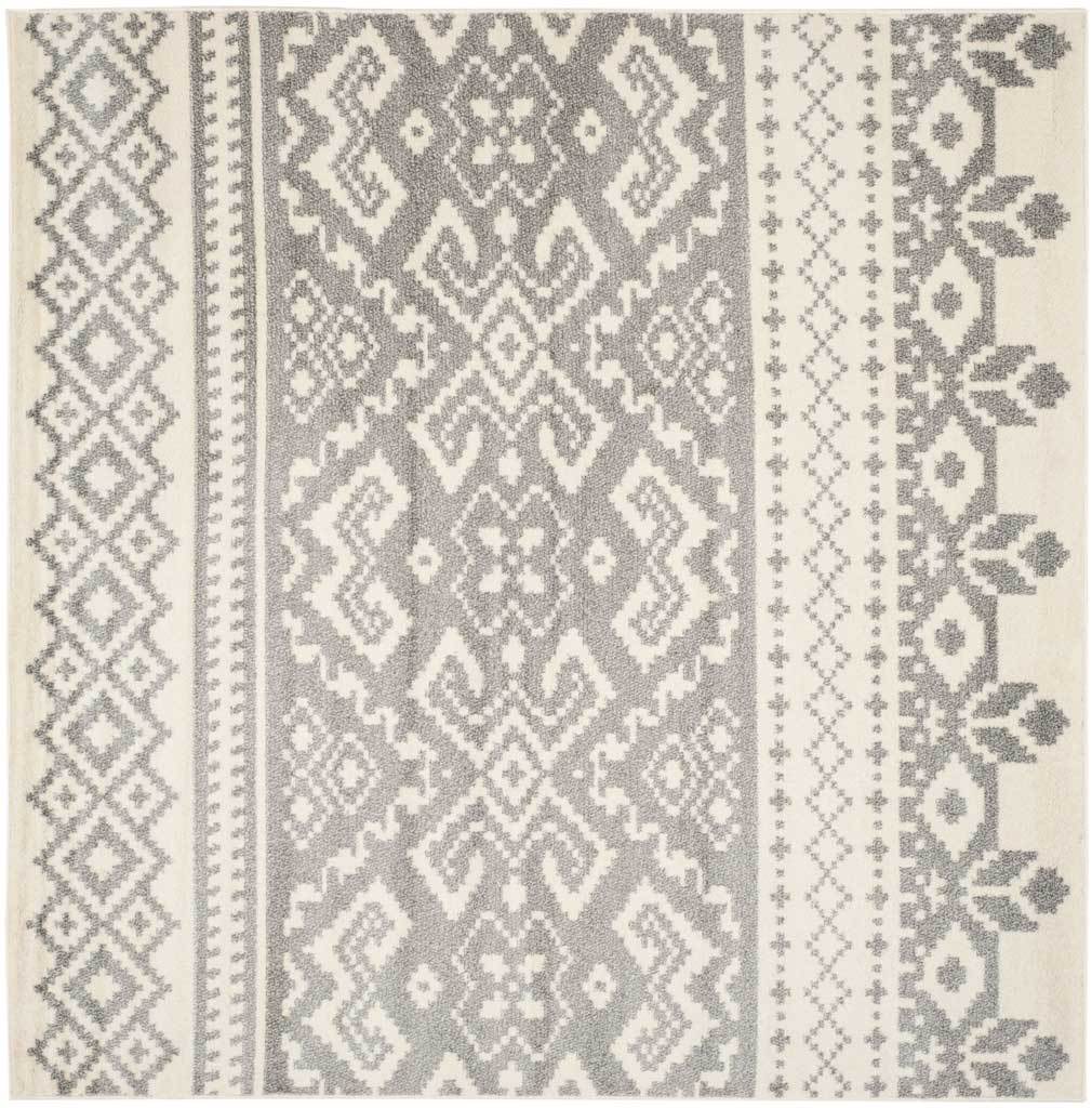 Large square ivory and silver rug showcases repeating medallions flanked by geometric and floral bands.
