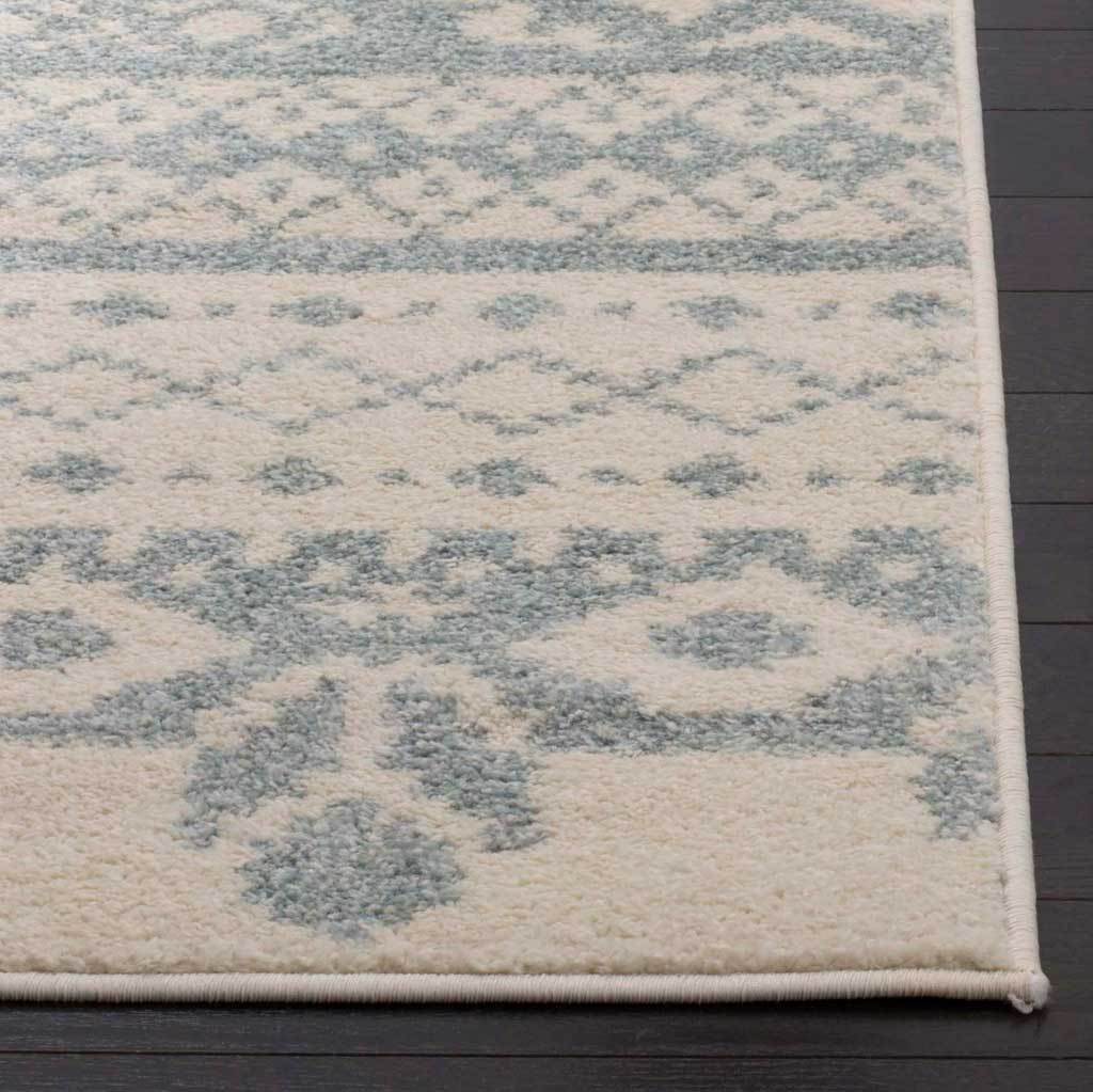 Slate floral sprigs stand out on soft ivory pile above a neatly bound edge.