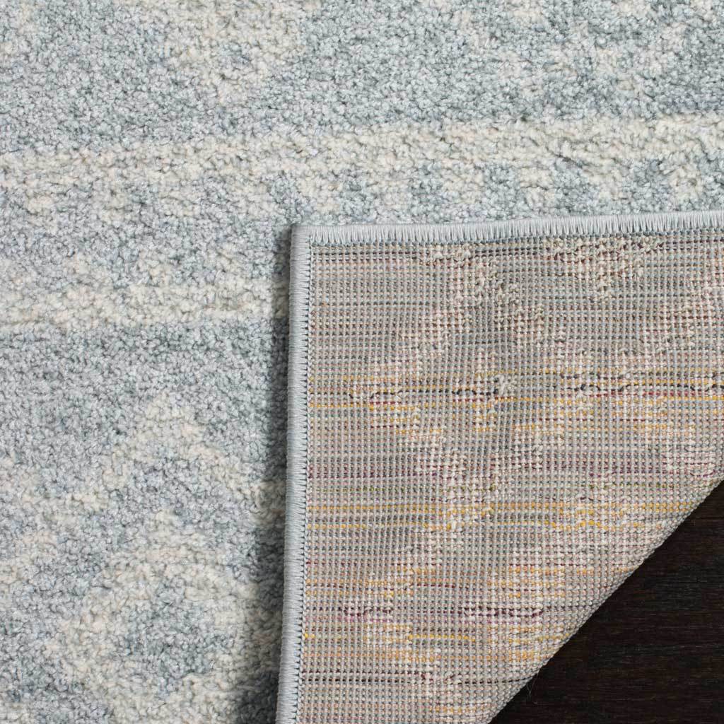 A closely woven underside and neat edge stitching support the softly patterned slate and ivory pile.