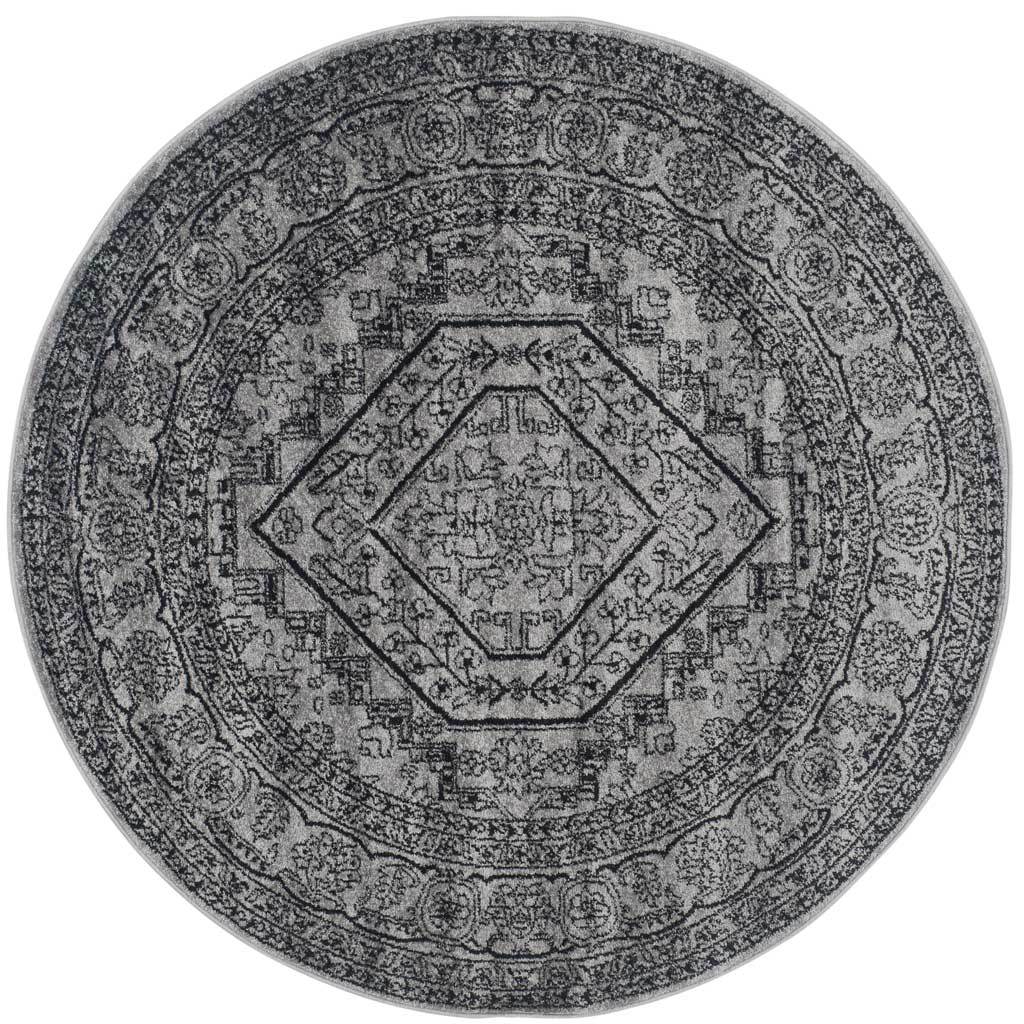 Silver and black round rug with a bold diamond medallion and densely patterned border