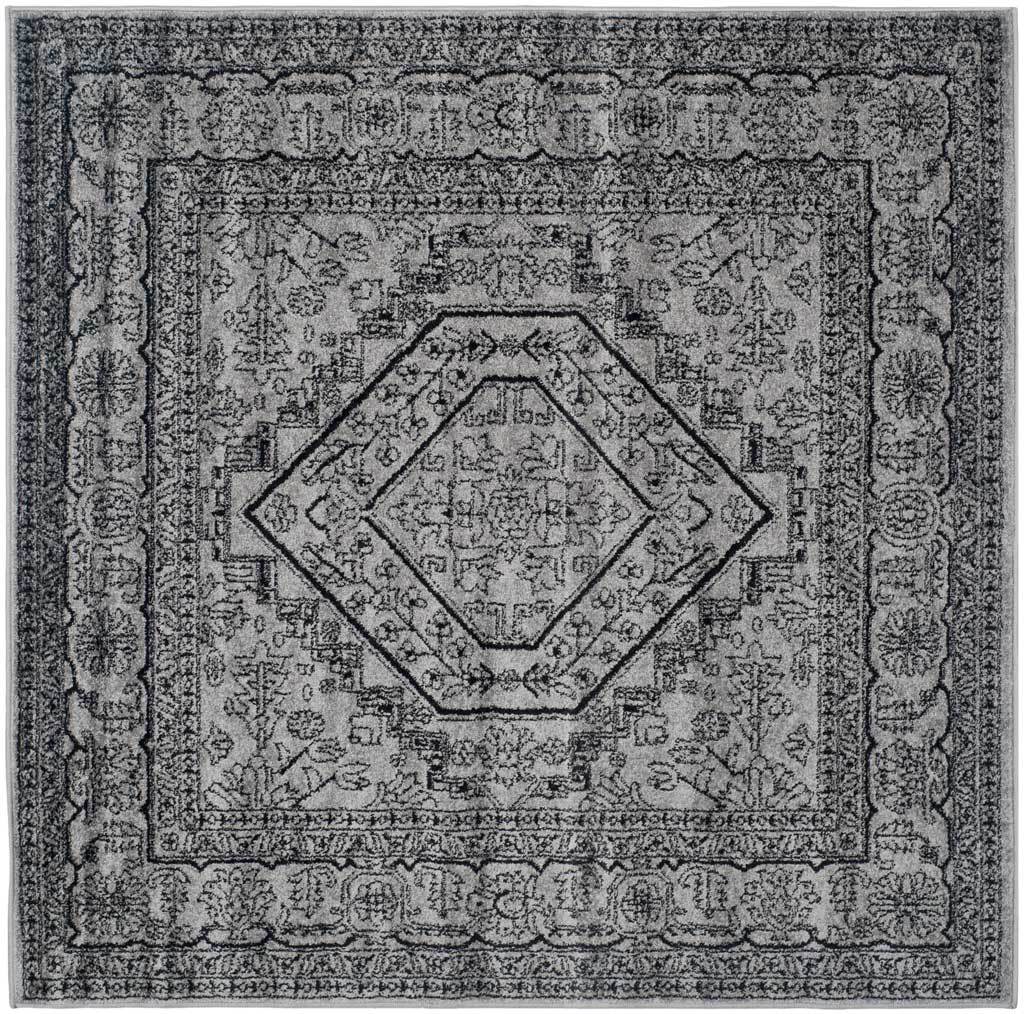 Silver and black square rug layers a geometric center over soft botanical details.