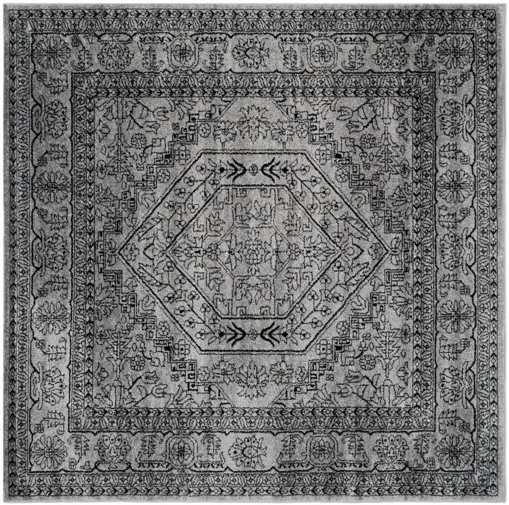 Square silver rug centers a bold black medallion amid symmetrical floral borders.
