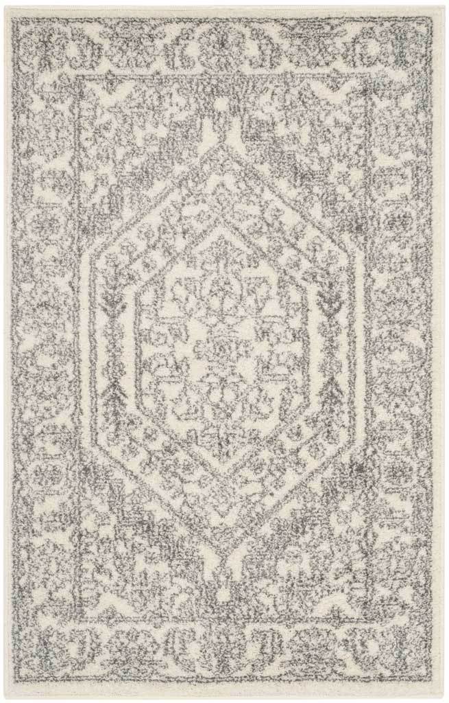 Compact ivory rug features a softly distressed silver medallion and floral accents.