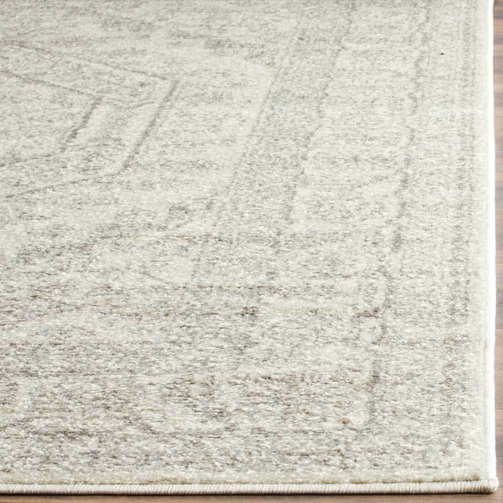 Pale silver tracery blends into plush ivory pile at a neatly finished corner.