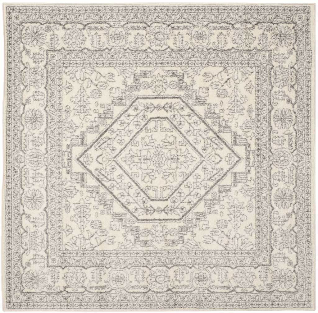 Square ivory rug features a soft silver geometric center and scrolling floral frame.