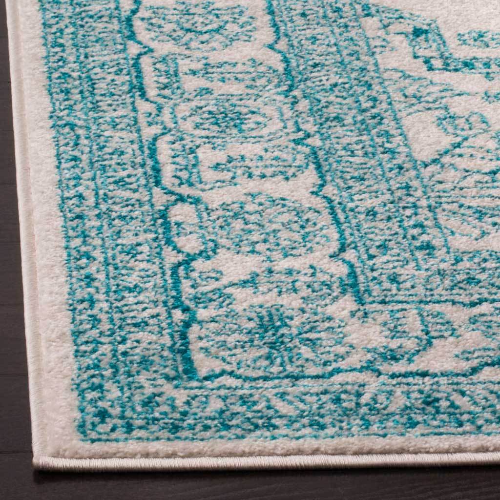 Vivid teal floral outlines stand out in the ivory pile around a neatly finished corner.