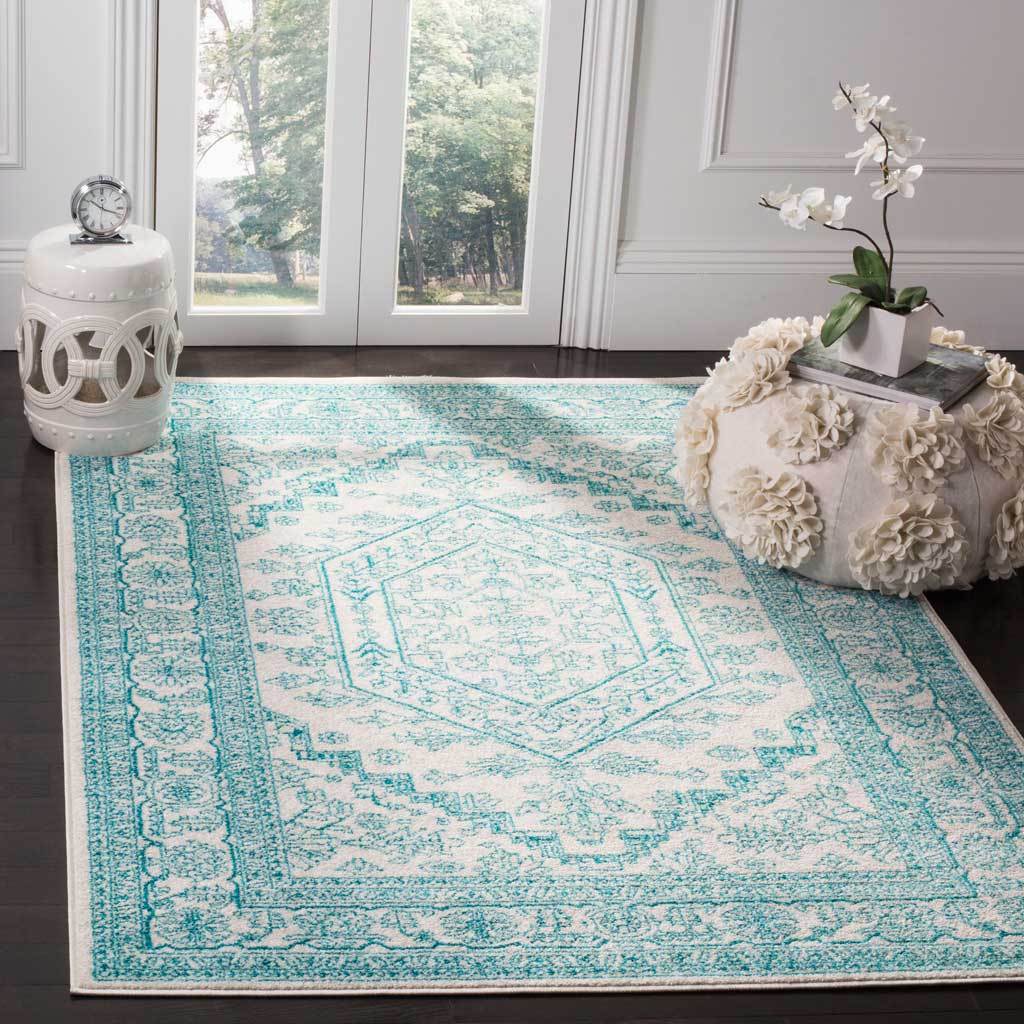 Teal floral borders and a crisp medallion bring fresh color to this ivory area rug.