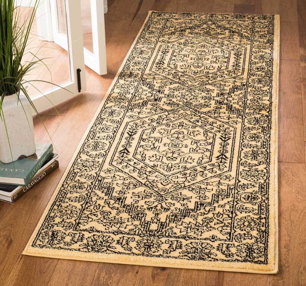 Golden runner rug with bold black scrollwork and two framed medallions