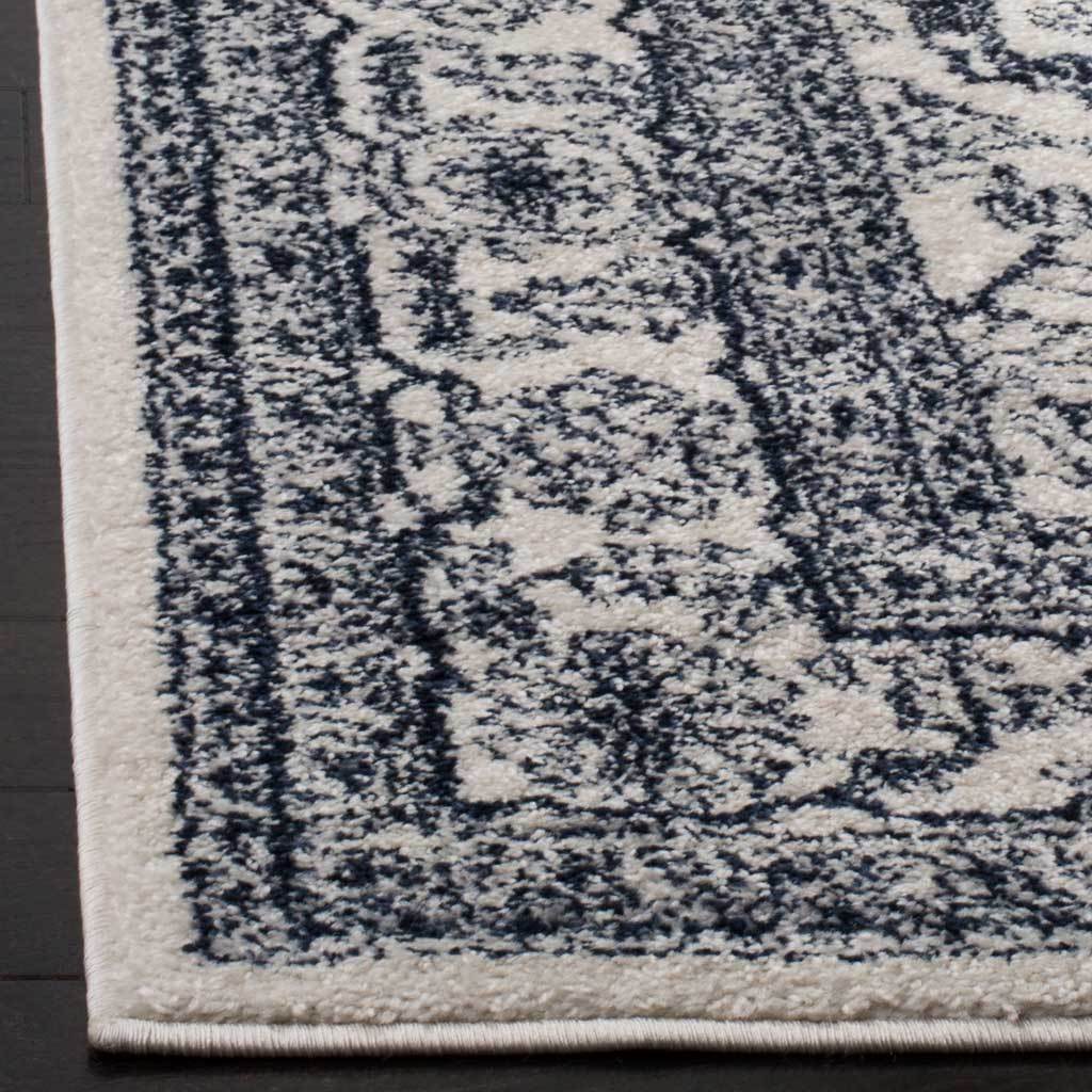 Navy scrolls frame the ivory rug's soft pile and cleanly bound corner.