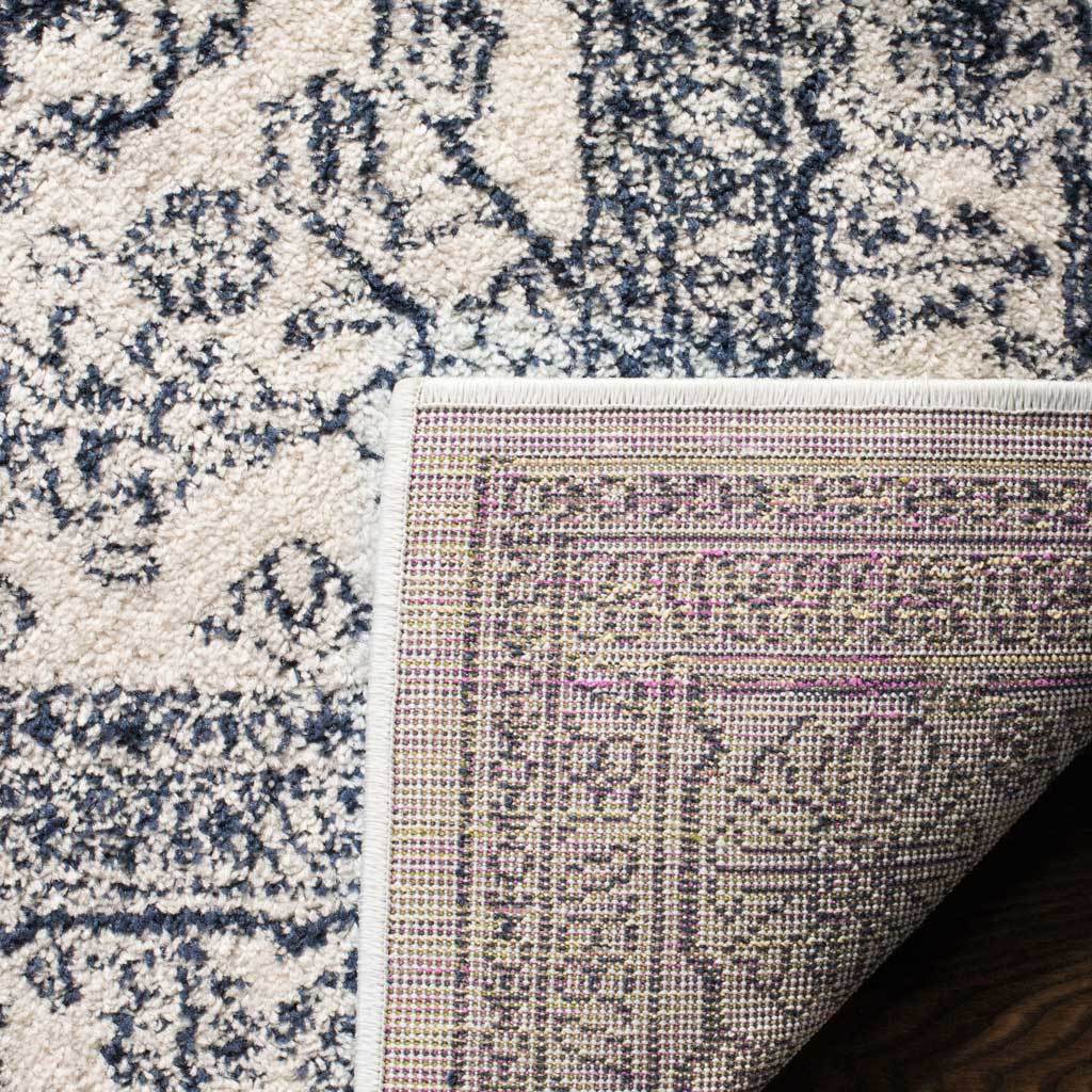 A turned-back corner reveals woven backing beneath the ivory and navy design.