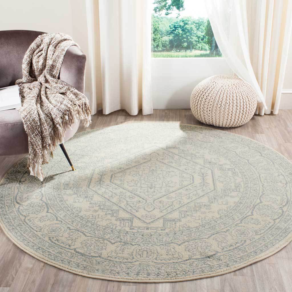 Ivory and slate round rug adds subtle traditional pattern beneath cozy seating