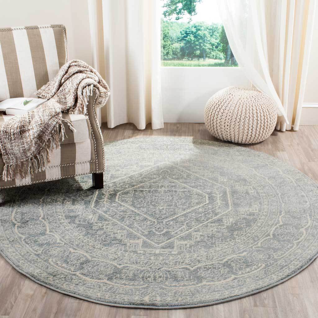 Slate and ivory round rug adds softly faded pattern beneath a cozy armchair