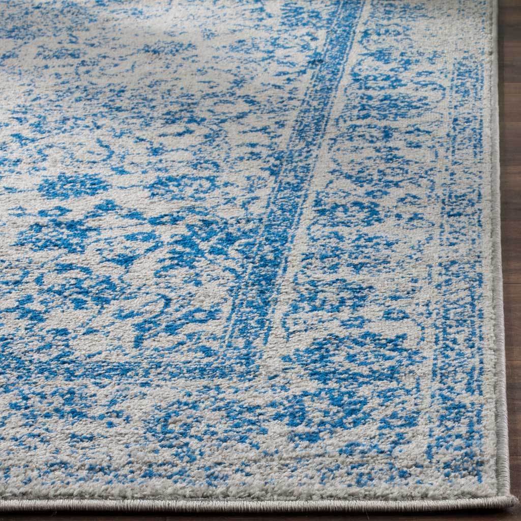 Blue floral pile meets a neatly bound edge on this distressed gray rug.