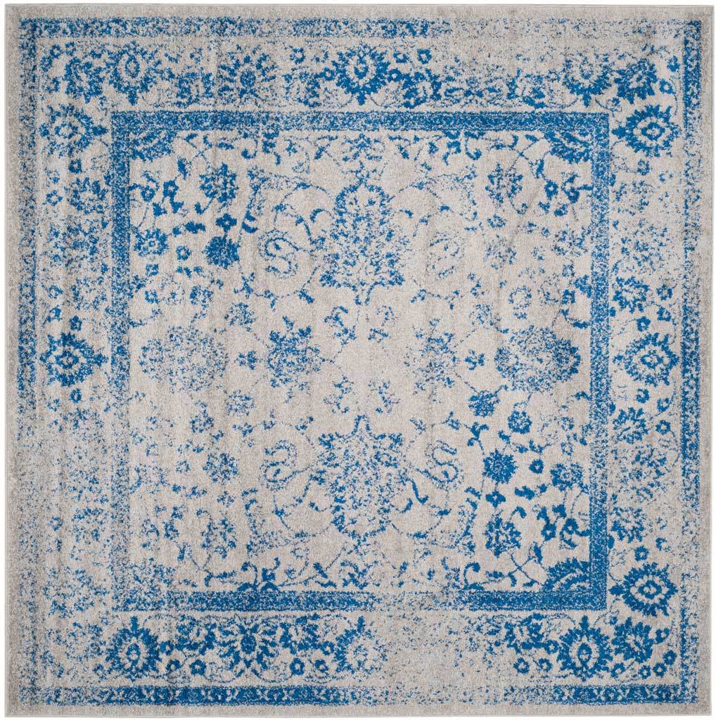 Bright blue florals frame a softly faded center on a square gray rug.