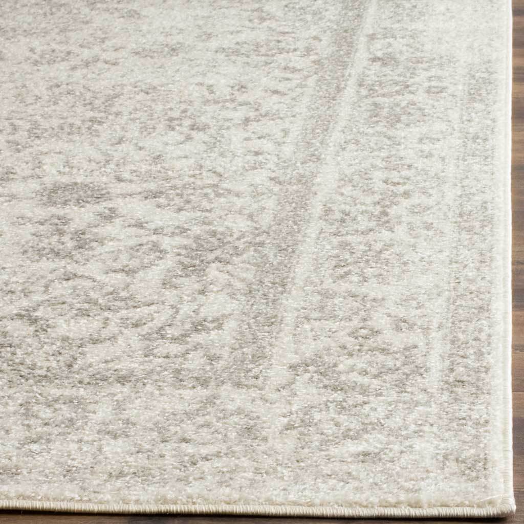 Pale silver flourishes soften the ivory pile along a cleanly finished edge.