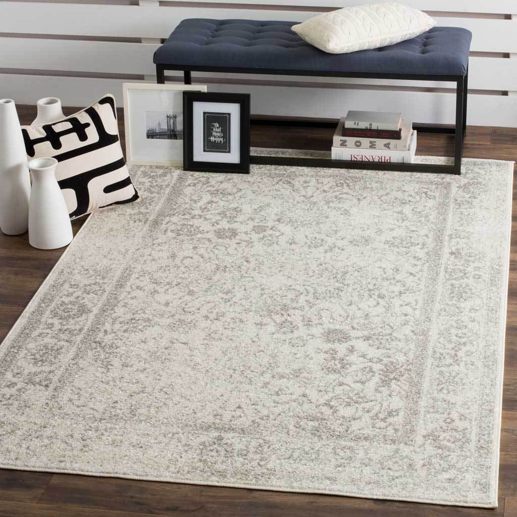 This ivory and silver rug brings subtle floral texture beneath a navy bench.