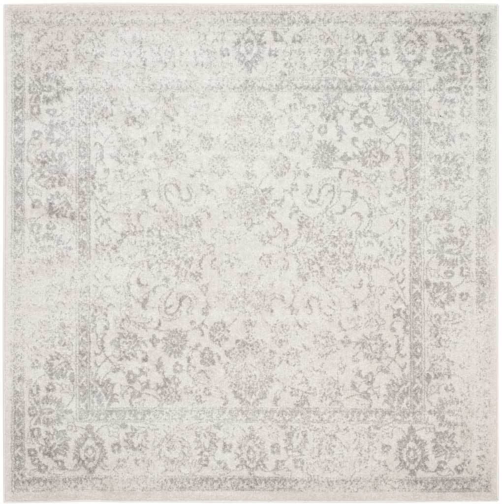 An ivory square rug carries a softly faded silver floral medallion and border.