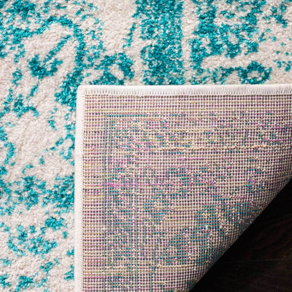 Folded back, the teal-and-ivory rug reveals a tightly woven reverse.