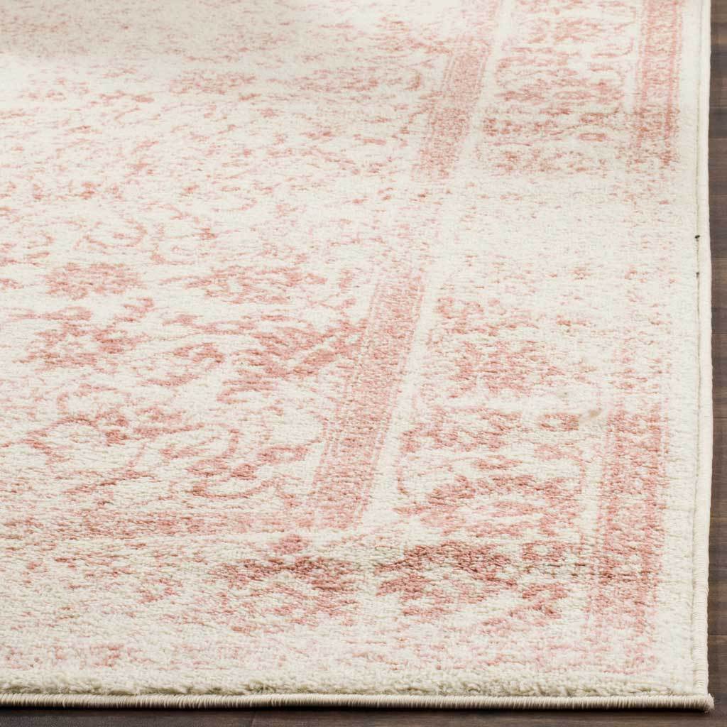 Rose floral tracery and plush ivory pile meet at the rug's finished edge.