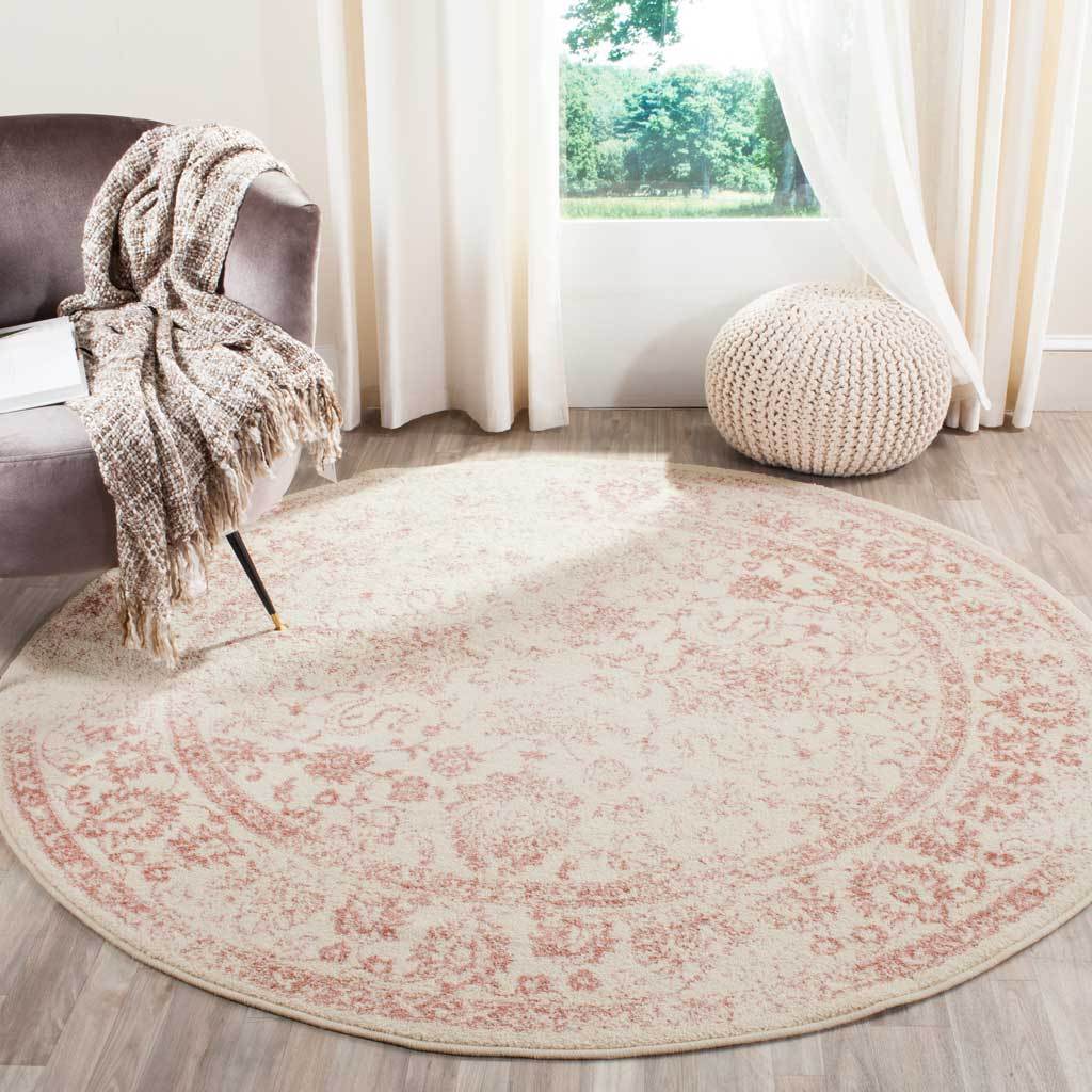 Delicate rose flourishes soften this round ivory rug's vintage-inspired design