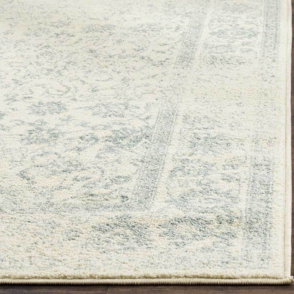 Fine slate flourishes thread through ivory pile beside a finished edge.