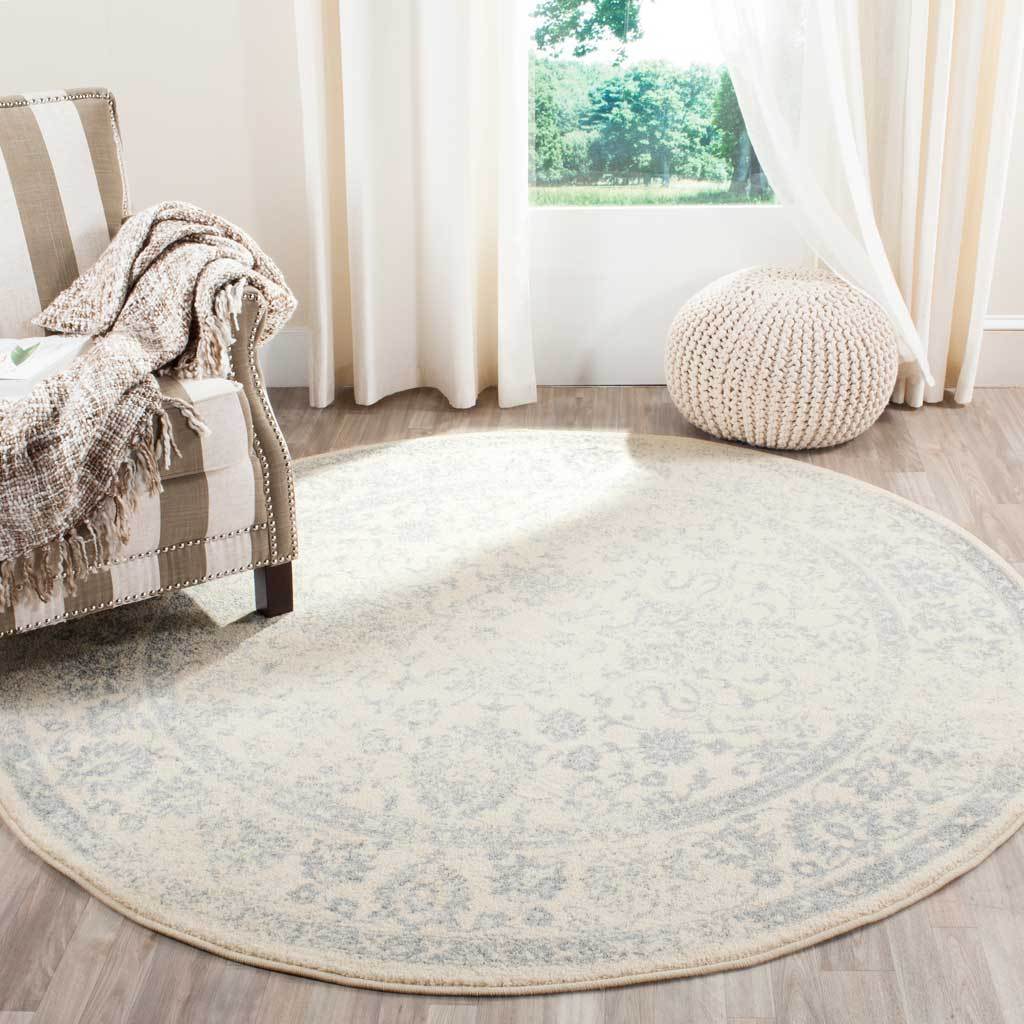 Faded slate detailing gives this round ivory rug an understated floral pattern