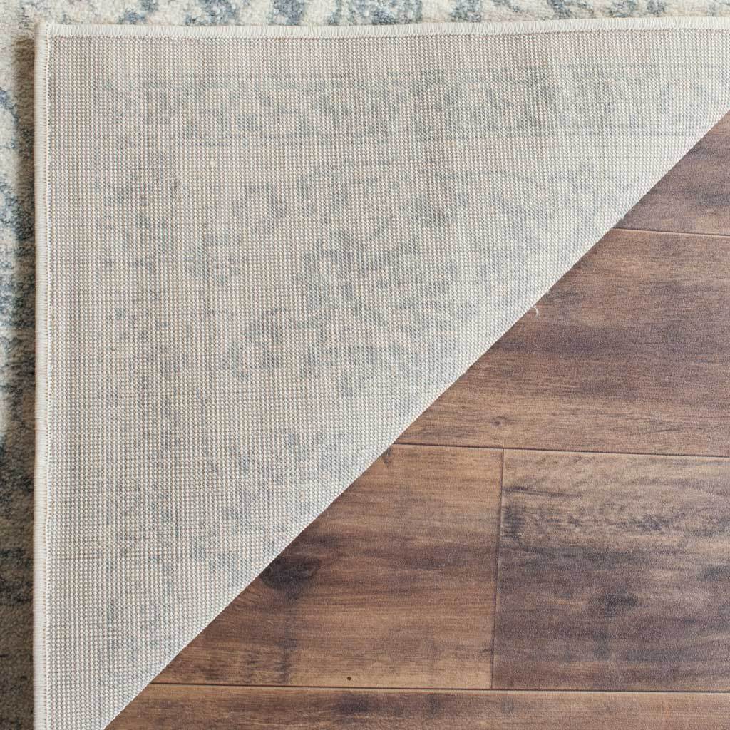 The folded edge reveals a woven backing beneath the ivory and slate pattern.