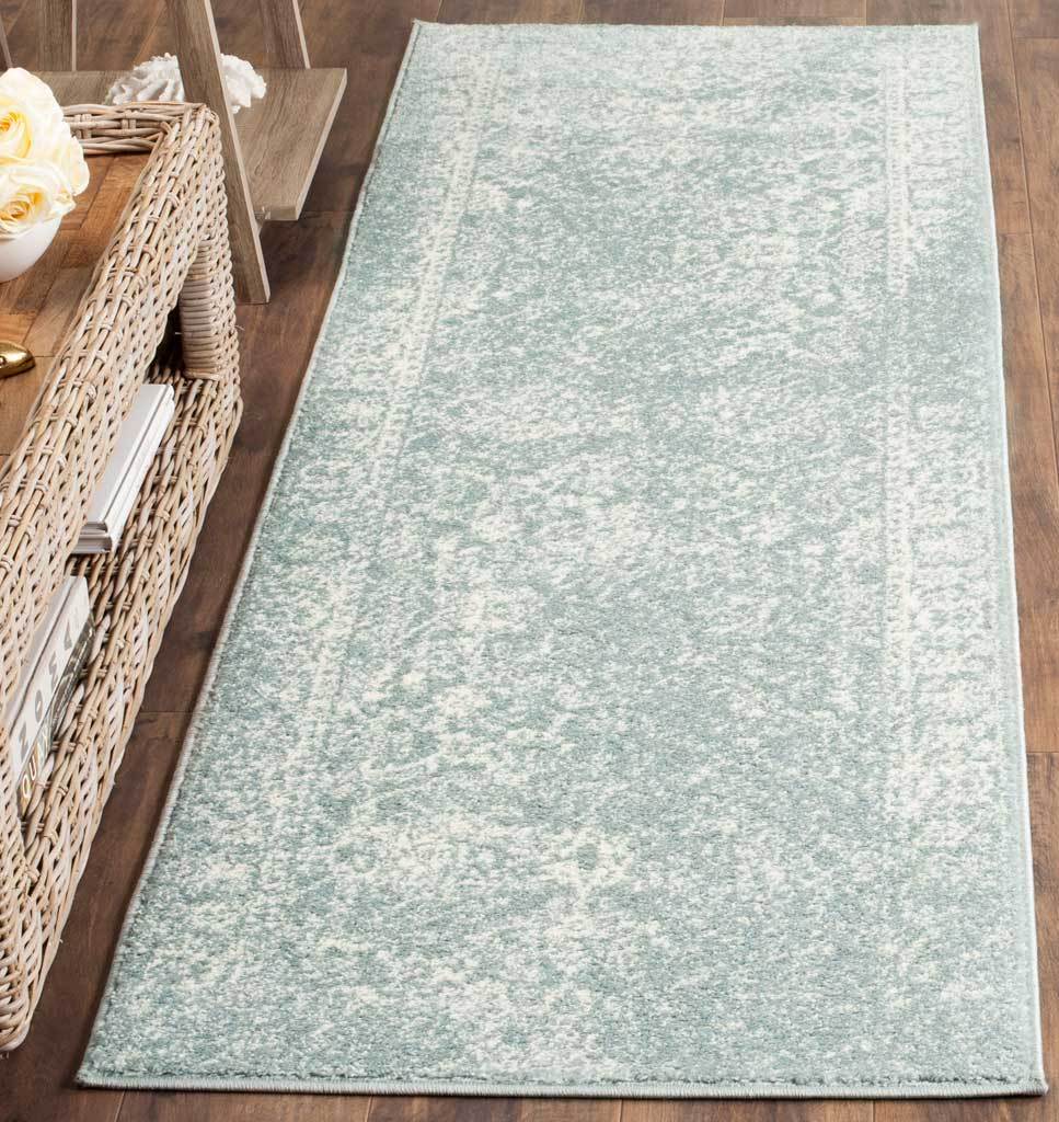 Cool slate and ivory hues highlight the runner rug's soft vintage pattern and border